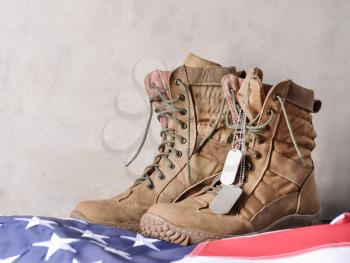 Military boots and USA flag on grey background�