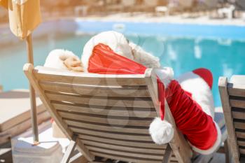 Santa Claus resting near swimming pool at resort�
