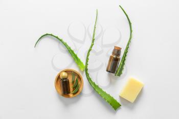 Essential oil with soap and aloe vera leaves on white background�