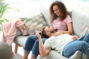 Happy young couple relaxing on sofa at home�
