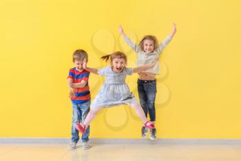 Cute little children having fun near color wall�