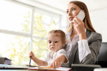 Working mother with her daughter in office�