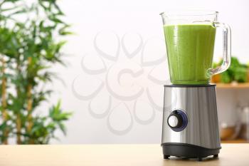 Blender with healthy smoothie on table in kitchen�
