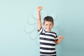 Portrait of happy little boy on color background�