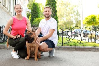 Sporty couple with cute dog walking outdoors�