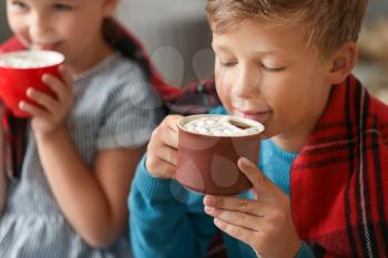 Cute little boy drinking hot chocolate at home on Christmas eve�