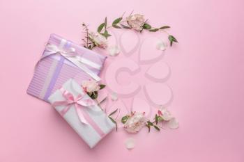 Gift boxes and beautiful flowers on color background�