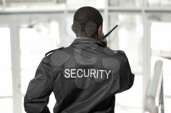 African-American security guard in building, back view�