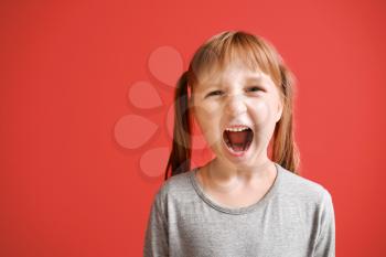 Portrait of angry little girl on color background�