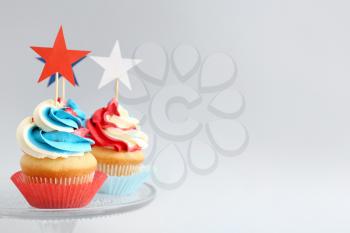 Tasty patriotic cupcakes on light background�