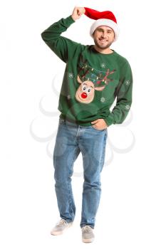 Young man in Christmas sweater and Santa hat on white background�