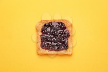 Tasty toasted bread with jam on color background�