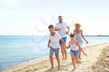 Happy family running on sea beach�