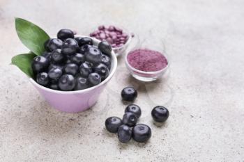 Acai berries with powder and tablets on light background�