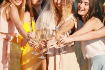 Beautiful young women with champagne at hen party outdoors�