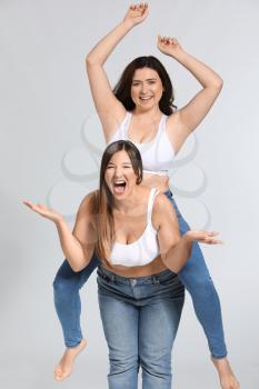 Young body positive women on grey background�
