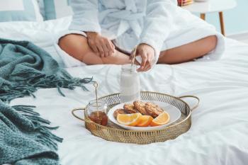Young woman having breakfast in bed�