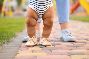 Cute little baby learning to walk outdoors�