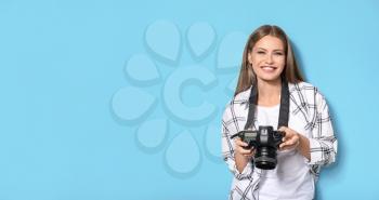 Beautiful female photographer on color background�