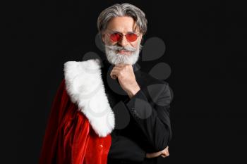 Portrait of stylish Santa Claus on dark background�