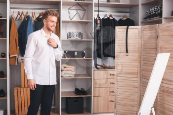 Handsome man trying on stylish clothes in dressing room�