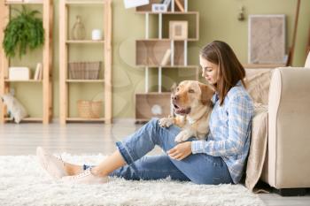 Beautiful young woman with cute dog at home�