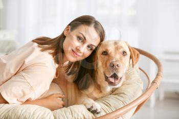 Beautiful young woman with cute dog at home�