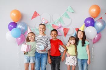 Happy children with Birthday gifts on light background�