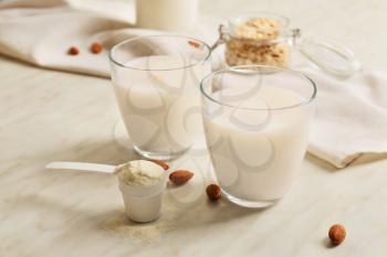 Glasses of protein shake on white table�