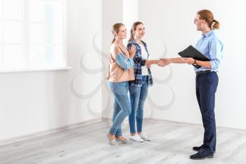 Woman shaking hands with real estate agent indoors�