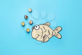 Composition with tasty sushi and drawn fish on color background�