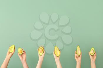 Female hands with fresh avocados on color background�