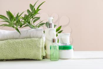 Cosmetics with towels on white table�