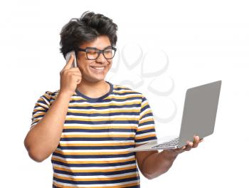 Male Asian programmer with laptop talking by mobile phone on white background�