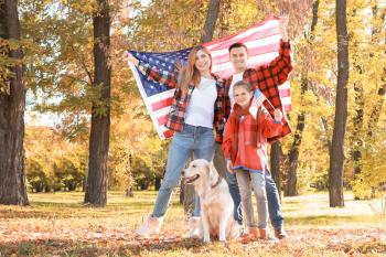 Happy family with national flags of USA in park. Memorial Day celebration�