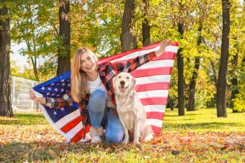 Happy woman and dog with national flag of USA in park. Memorial Day celebration�