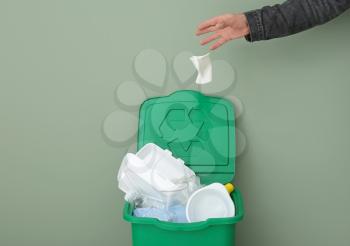 Man throwing garbage into container. Recycling concept�