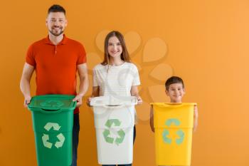 Family with containers for garbage on color background. Concept of recycling�