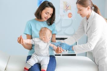 Pediatrician vaccinating little baby in clinic�