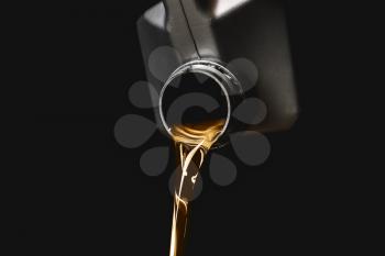 Can with pouring car oil on dark background�