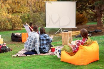 Friends watching movie in outdoor cinema�