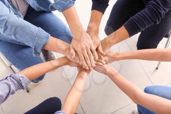 Young people putting hands together during psychological support session�