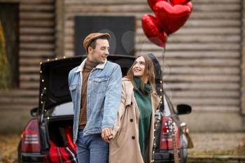 Happy young couple near car outdoors. Valentine's Day celebration�