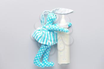 Bottle of milk for baby and toy on white background�