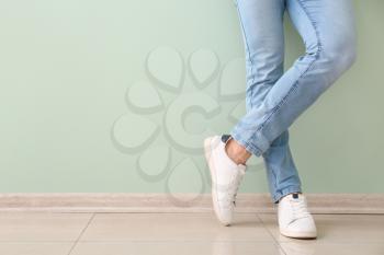 Young man in stylish shoes near color wall�