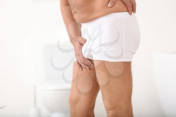 Mature man with urologic disease in bathroom�