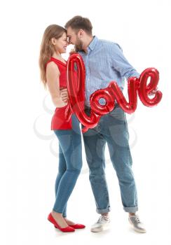 Happy young couple with balloon in shape of word LOVE on white background. Valentine's Day celebration�