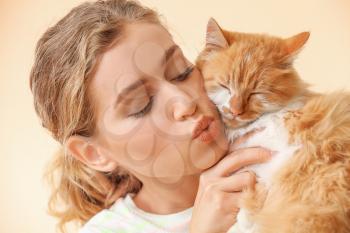 Beautiful young woman with cute cat on color background�