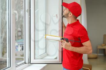 Young worker installing window in flat�