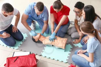 Instructors demonstrating CPR on mannequin at first aid training course�